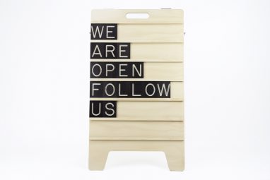 We are Open Follow Us - Message Displayed on Wooden Sandwich Board by One Two Tree Designs